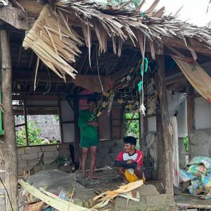 Familj i delvis ödelagt hus på Filippinerna.