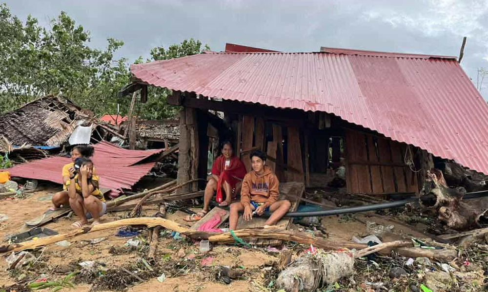 Familj sitter i raserat hus på Filippinerna.